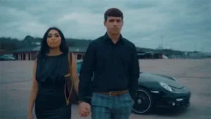 Man and women holding hands with porsche in background