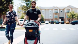 couple holding hands while pushing a stroller