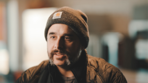 Man in beanie on camera.